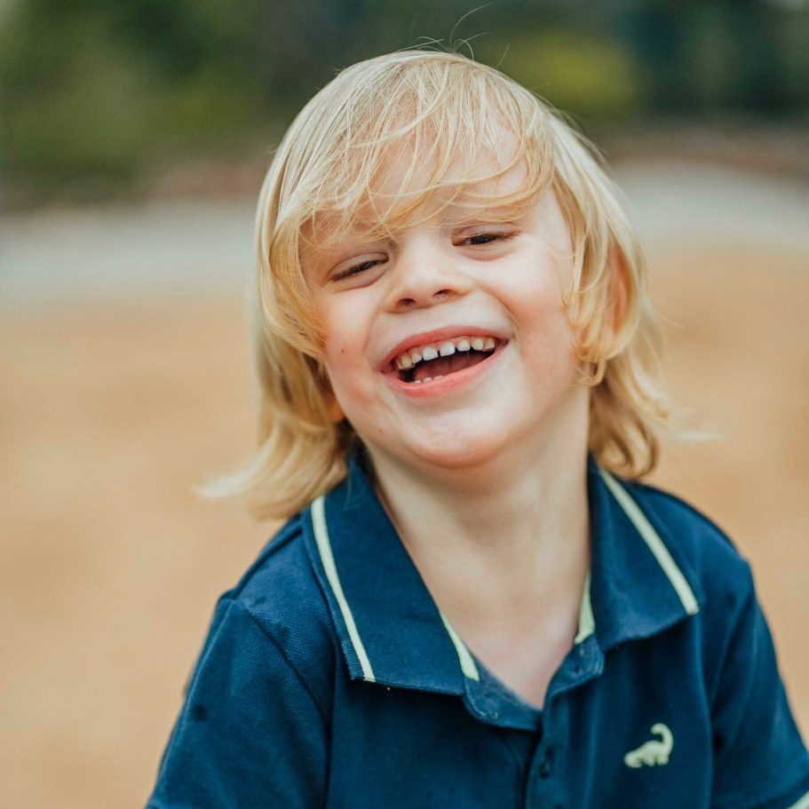 kindergarten bilder werteim Lachender Junge mit blonden Haaren und blauem Polohemd im Freien beim Fototag in Wertheim