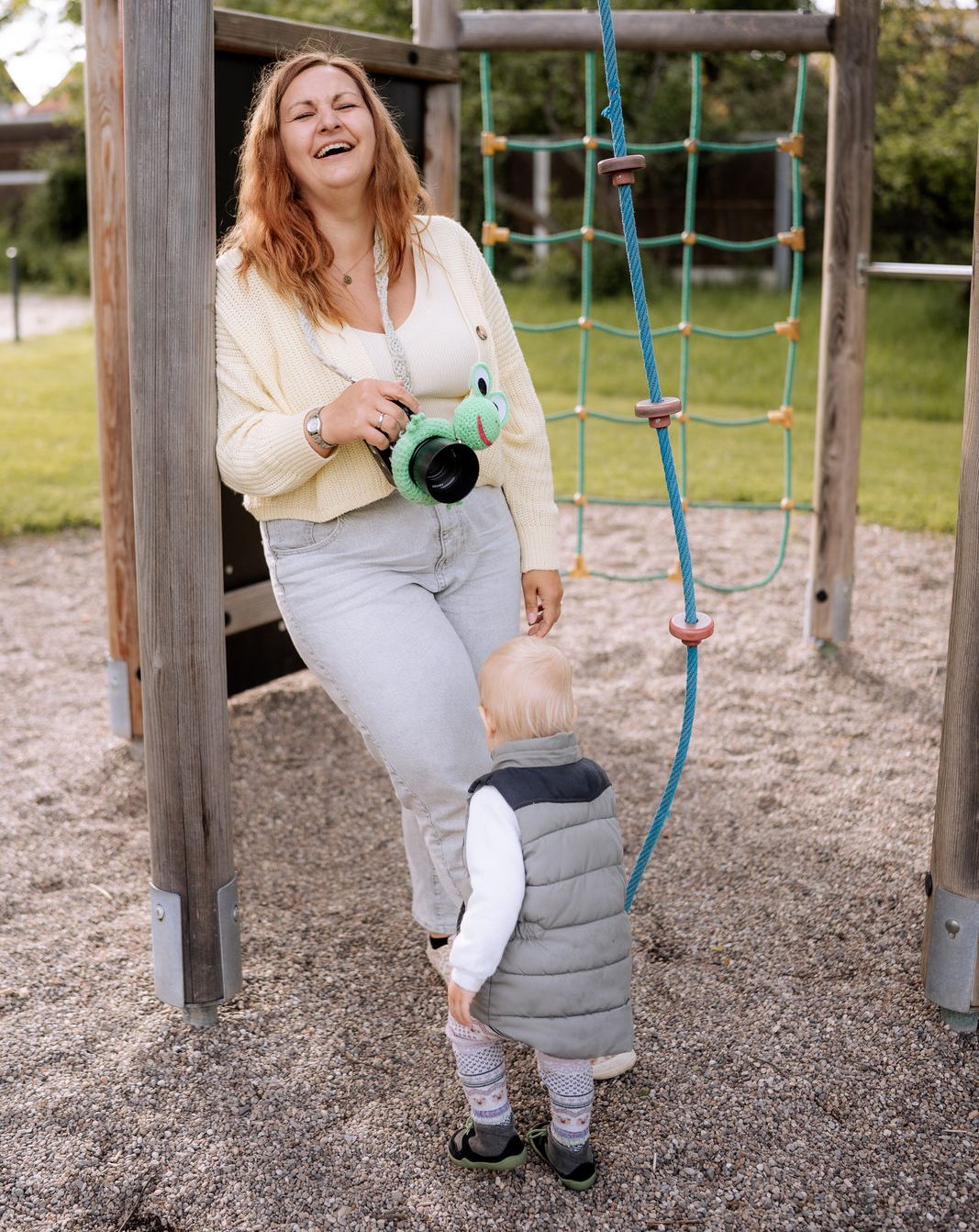 Familie im Freien: Eine Frau mit roten Haaren, ein Mann mit blauen Haaren und ein Baby.