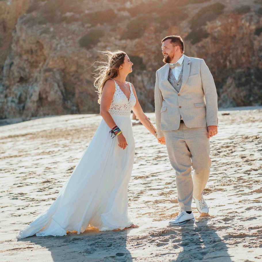Braut und Bräutigam in eleganter Hochzeitskleidung am Strand, romantische Stimmung.