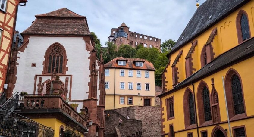 Fotografin Wertheim Historische Gebäude mit einer Burg im Hintergrund und einer steilen Treppe.